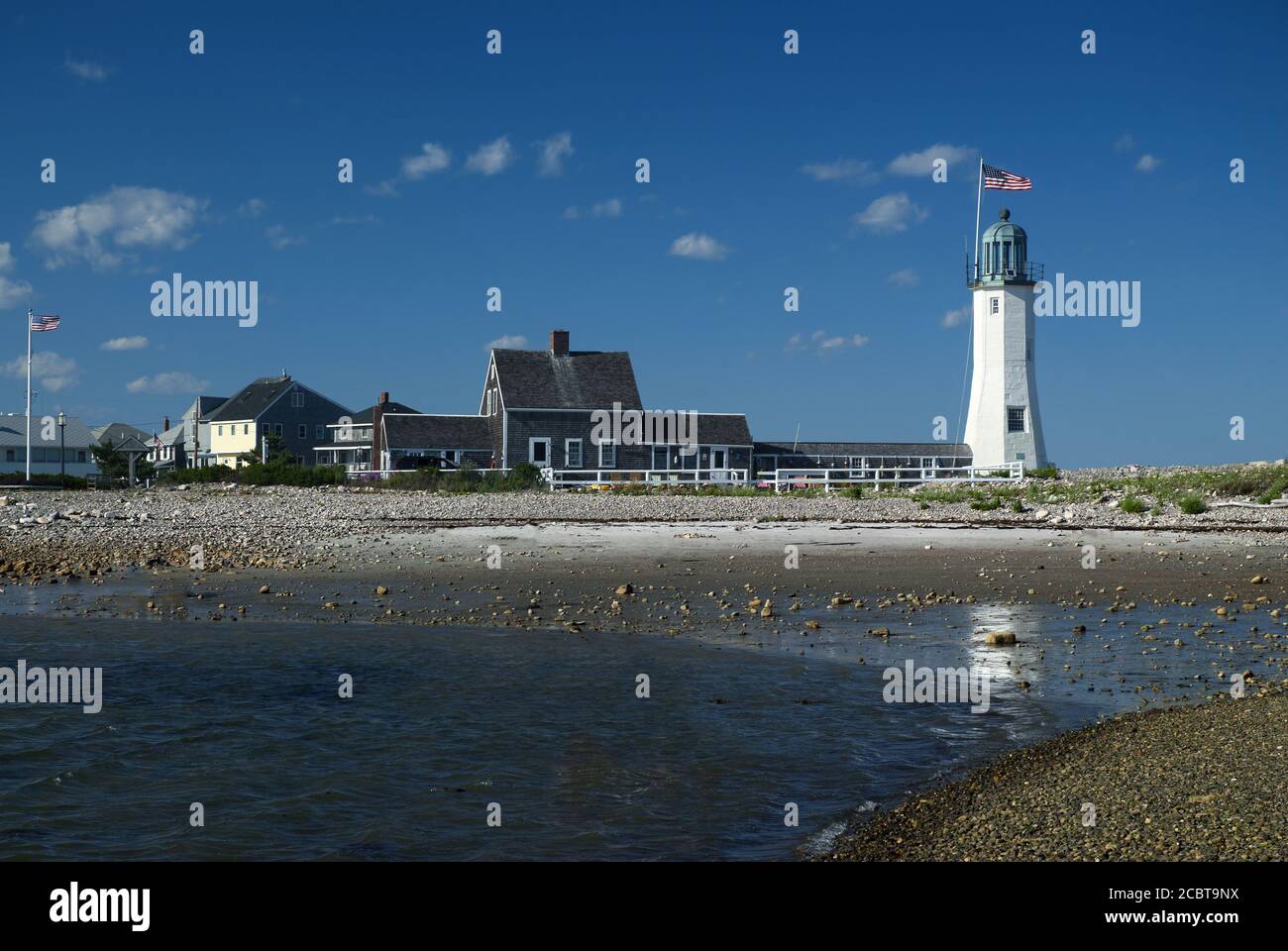 La spiaggia di sabbia accanto al faro di Scituate Harbour è un'attrazione gradita a molti turisti in Massachusetts, con la sua torre e l'edificio unici. Foto Stock