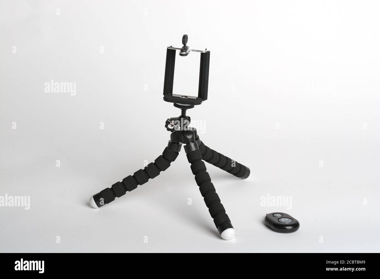 treppiede nero per selfie su sfondo bianco Foto Stock