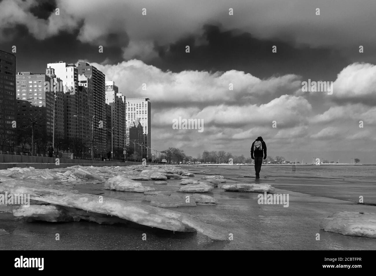 Uomo che cammina da solo lungo il ghiacciato lungolago di Chicago Foto Stock
