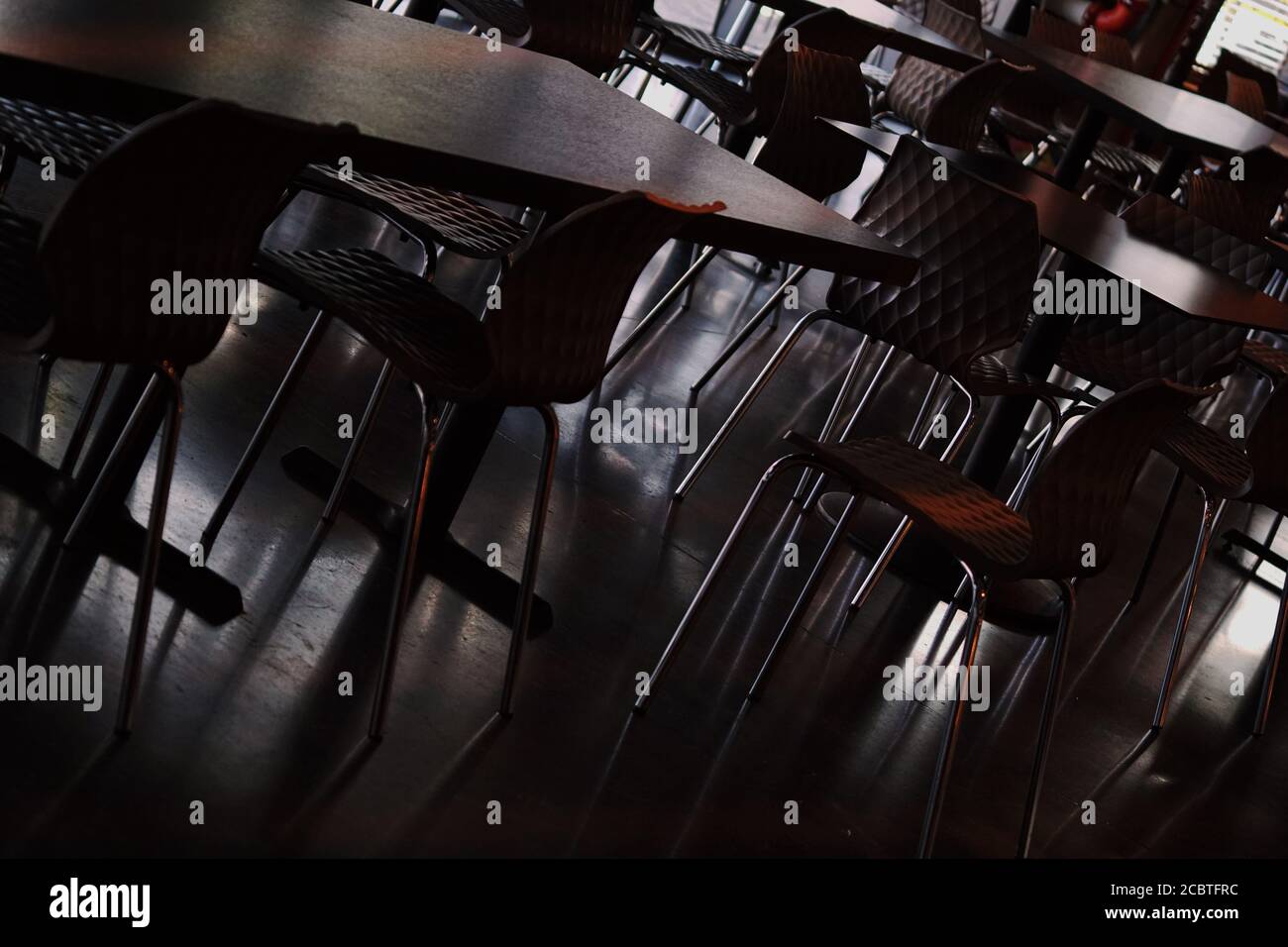 vista ad angolo basso della camera piena di sedie e tavoli Foto Stock
