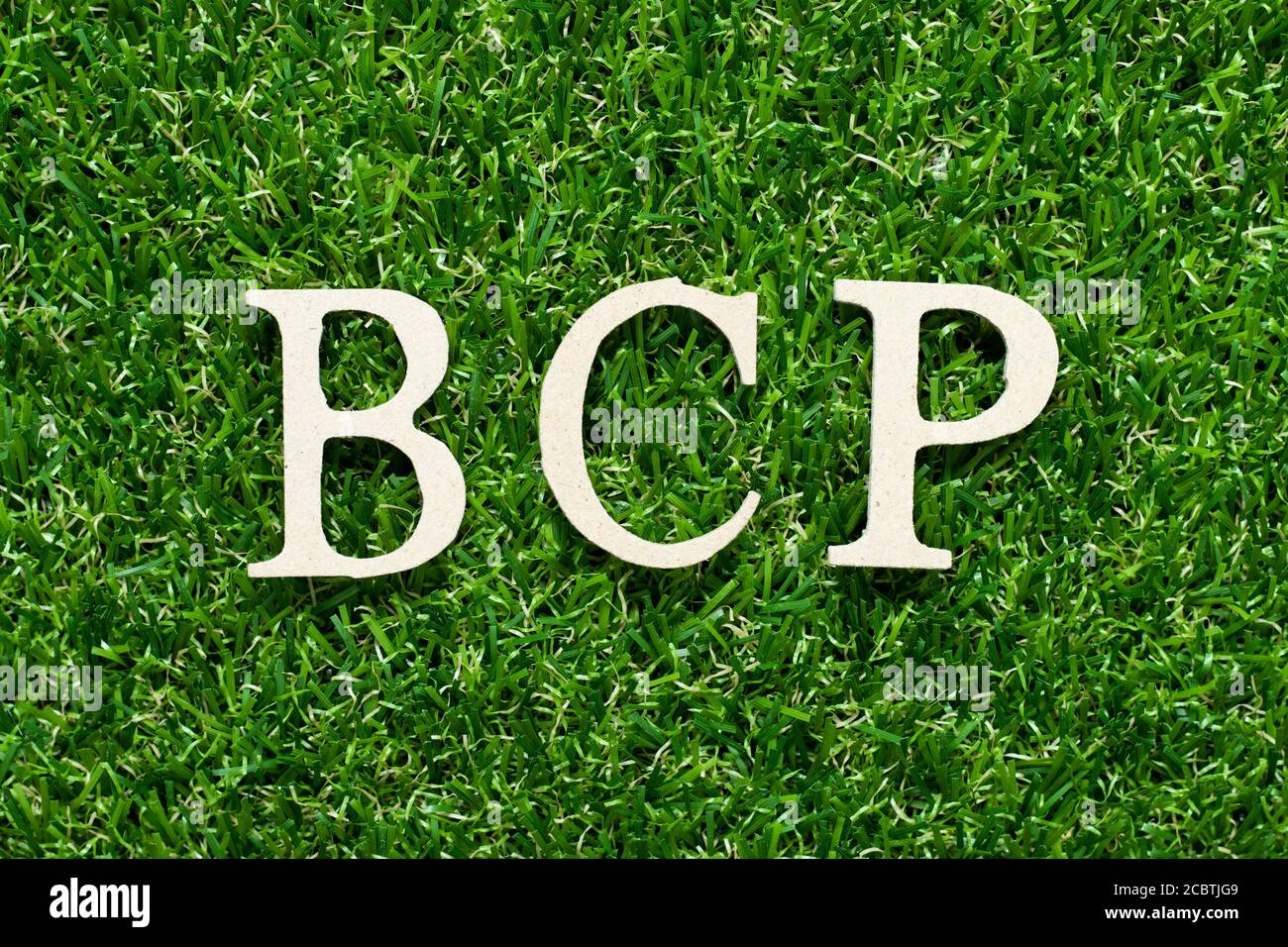 Lettera alfabetica in legno in parola BCP (abbreviazione business continuity plan) su sfondo verde erba Foto Stock
