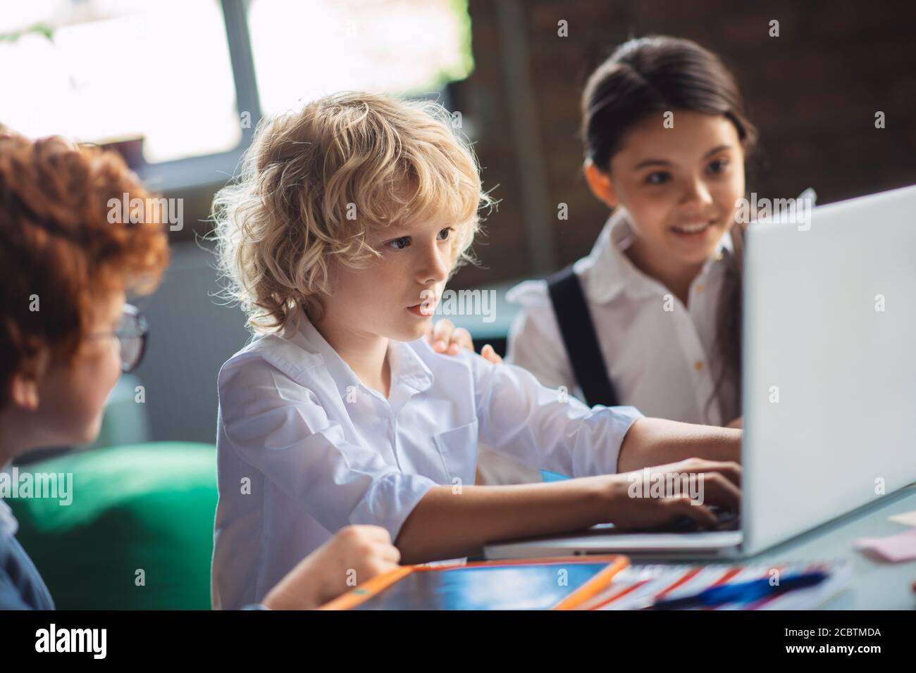Tre bambini carini che studiano in classe Foto Stock
