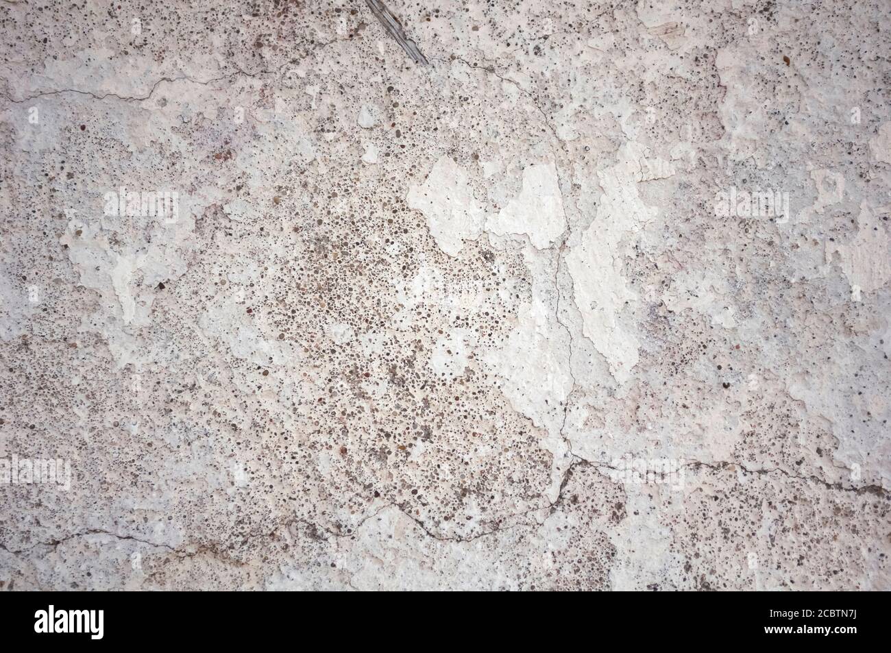 Gesso bianco lucido Destroid. Il vecchio intonaco non è stato rimosso dalla parte anteriore prima dell'aggiornamento. Intonaco con crepe, da cui si può vedere piccola bla Foto Stock
