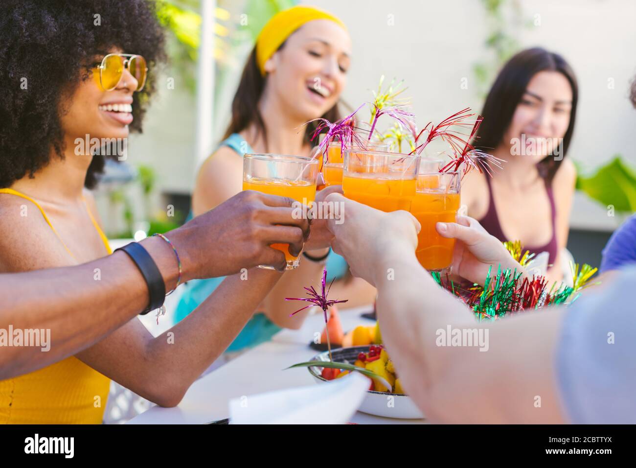 Immagine di un gruppo multirazziale di amici che brinda con cocktail - concetto di amicizia, celebrazione e vacanza Foto Stock