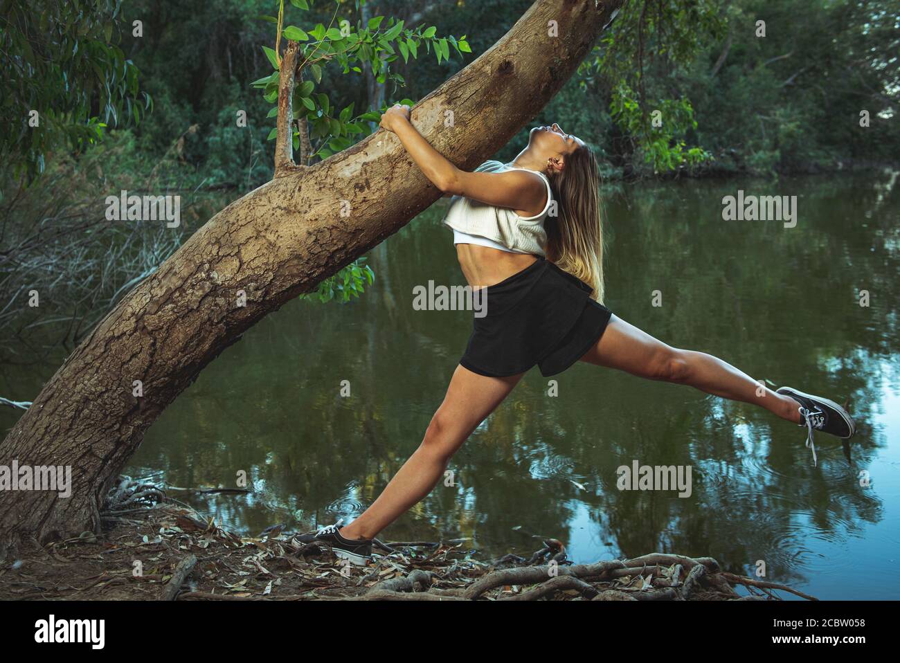 Giovane ballerina contemporanea e coreografo che danzano all'aperto nella foresta. Donna che balla nell'ambiente. Foto Stock