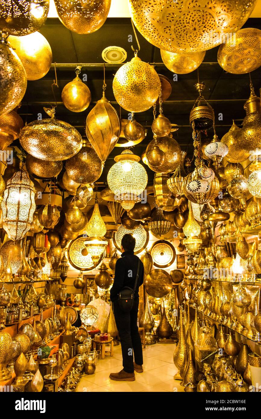 Un viaggiatore maschile che guarda lanterne e vasi in un negozio Foto Stock