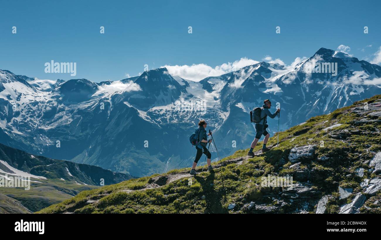 Due giovani escursionisti che camminano su una montagna in Austria, con viste panoramiche sullo sfondo Foto Stock