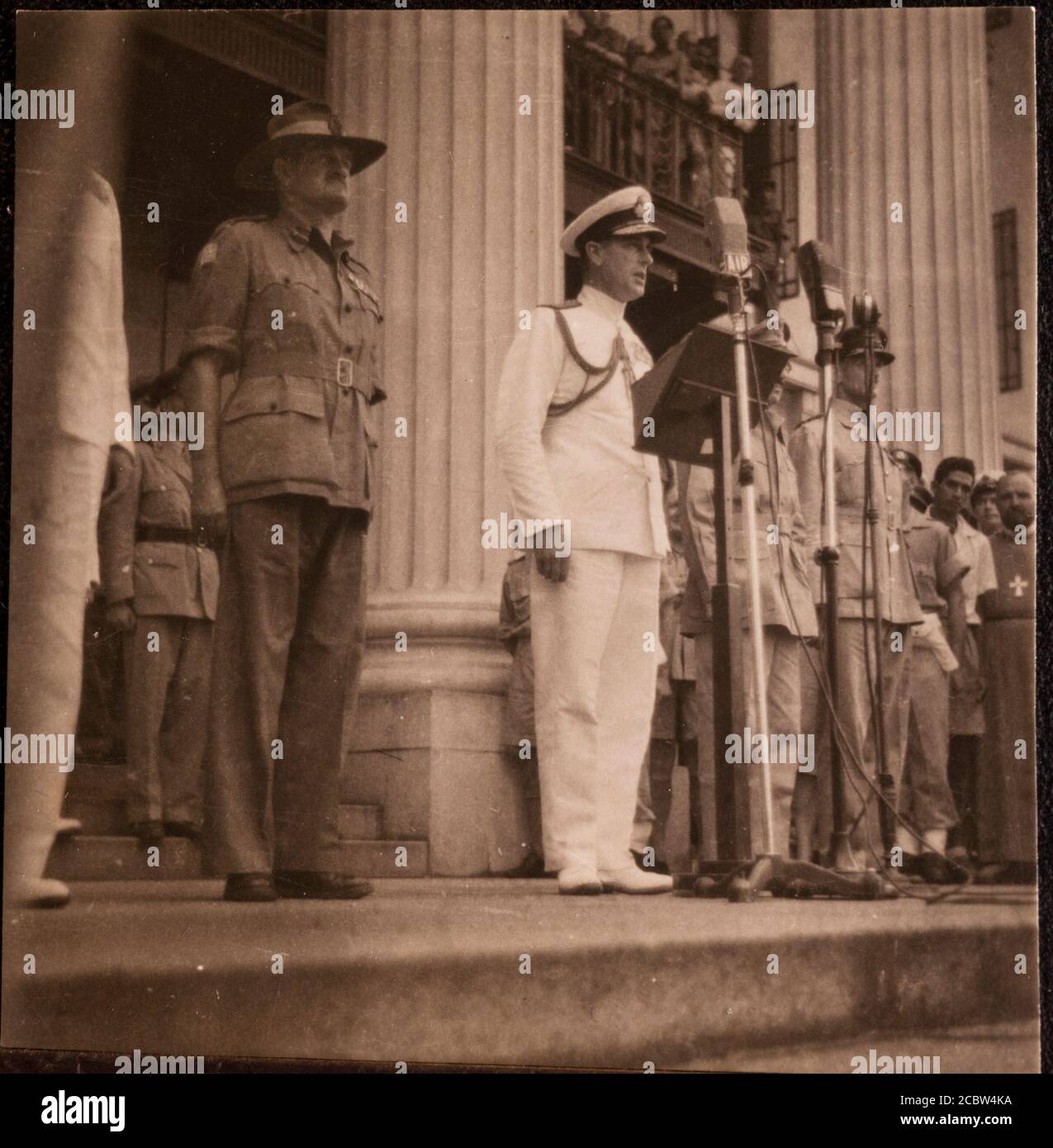 Giapponese rinuncia a Lord Louis Mountbatten a Singapore 12 settembre 1945 queste stampe fotografiche originali sono state acquistate a casa dall'Estremo Oriente dal padre dei fotografi in fondo ad una cassetta degli attrezzi dopo la guerra. Sono in un album di famiglia e copiati da questo fotografo Supremo Comandante alleato Sud Est Asia: La resa giapponese a Singapore: L'ammiraglio Mountbatten che consegna un discorso sui gradini del Municipal Building a Singapore dopo la cerimonia di consegna. Da sinistra a destra: Generale William Slim (in cappello), ammiraglio Lord Mountbatten (al microfono, in bianco), tenente Gener Foto Stock