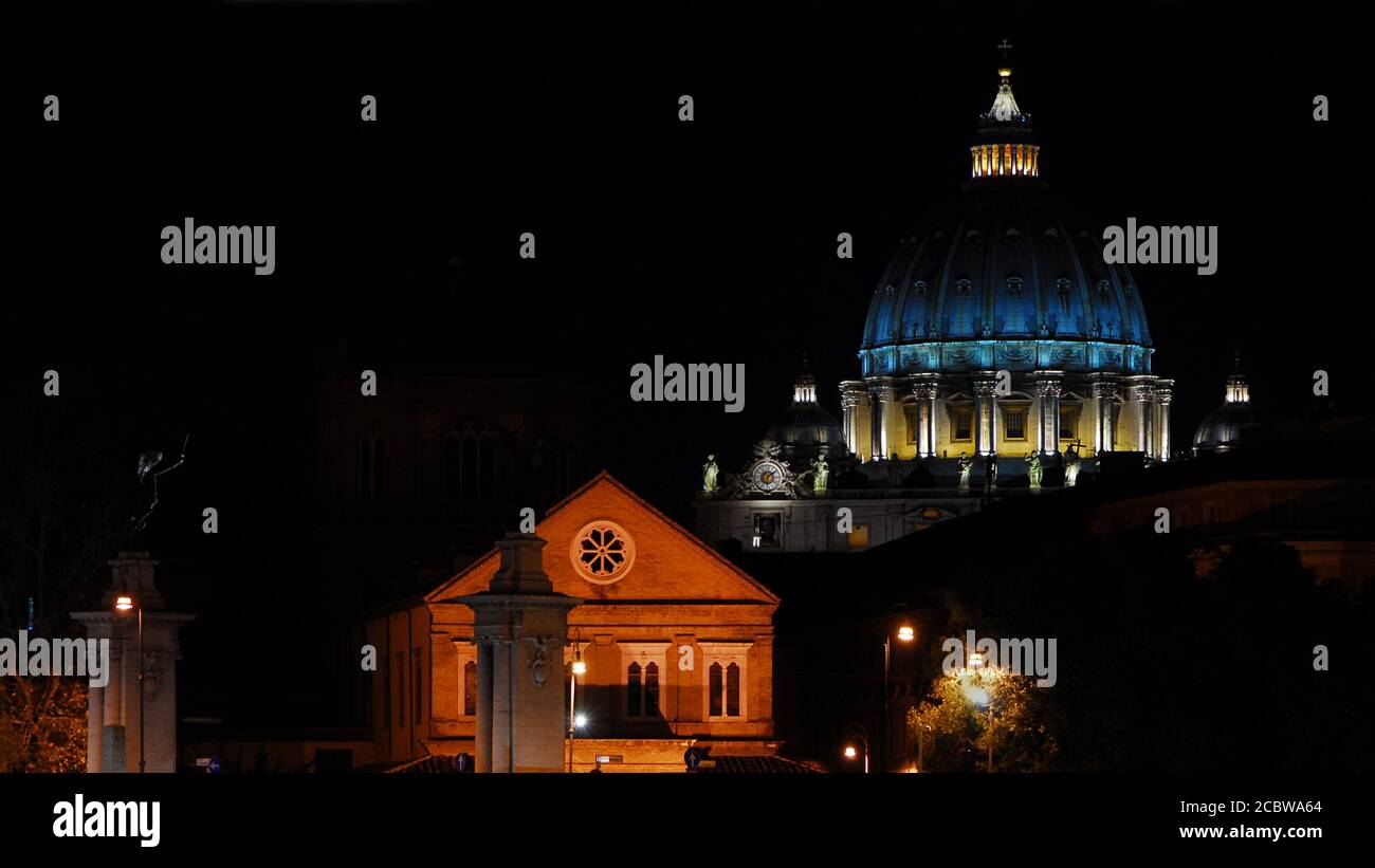 Notte a Roma. Vista dell'iconica cupola di San Pietro illuminata, nel centro storico della città Foto Stock