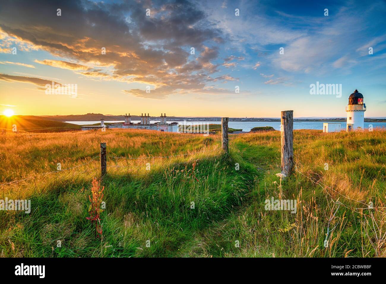 Splendido tramonto sul faro e sui cottage della guardia costiera ad Arnish Punto vicino a Stornoway sull'Isola di Lewis nel Ebridi esterne della Scozia Foto Stock