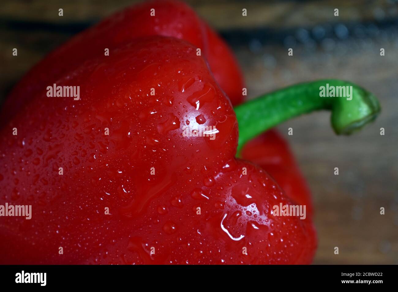 Foto ravvicinata del pepe rosso bagnato con gocce d'acqua. Foto Stock