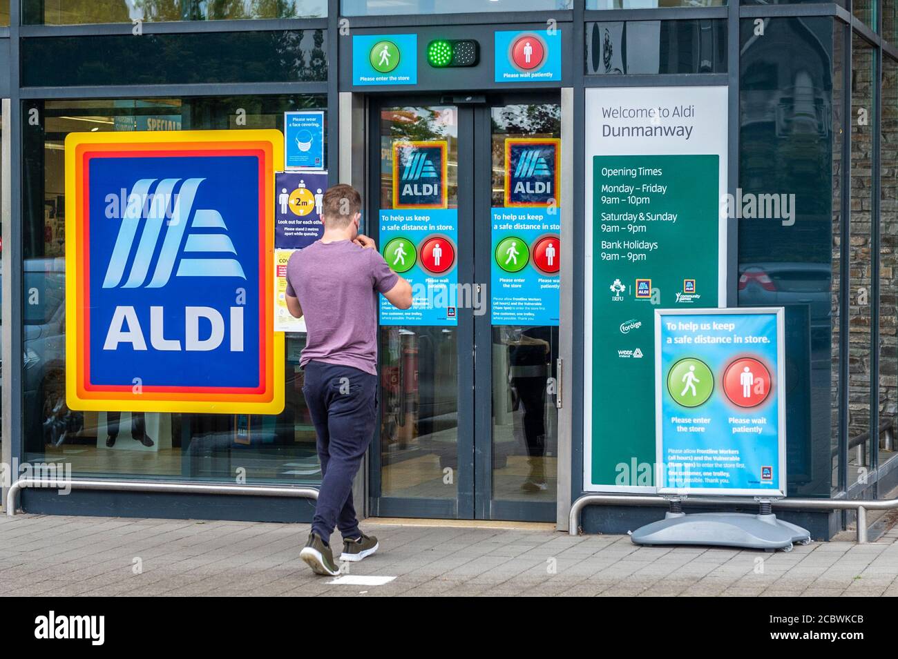 Dunmanway, West Cork, Irlanda. 16 agosto 2020. Aldi a Dunmanway ha un sistema di entrata del semaforo in atto per ridurre il numero di persone in negozio in qualsiasi momento a causa di COVID-19 linee guida di distanziamento sociale. Un acquirente entra nel negozio. Credit: AG News/Alamy Live News Foto Stock
