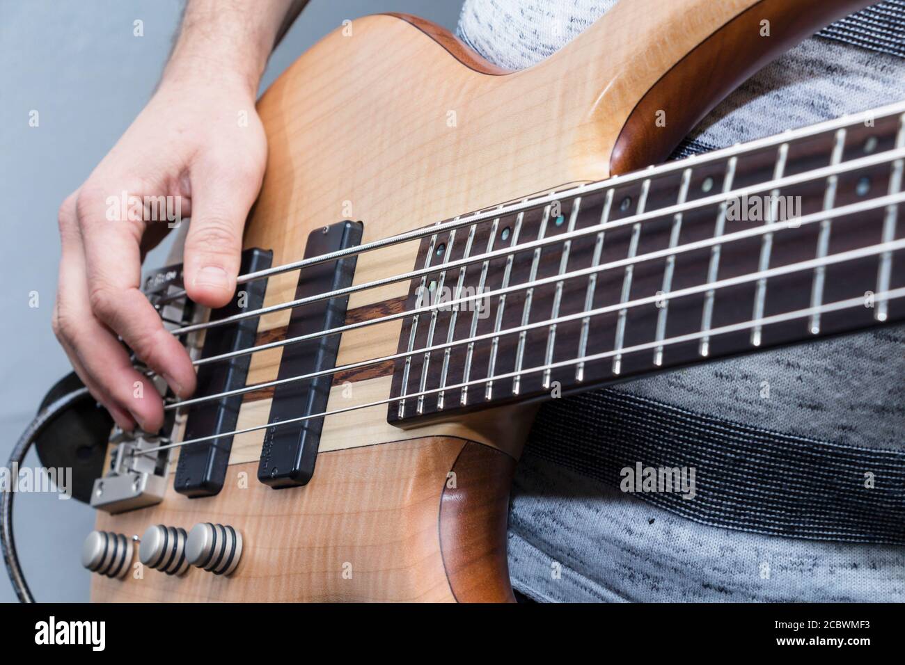 Primo piano della chitarra basso le mani del giocatore, soft il fuoco selettivo, live musica tema Foto Stock