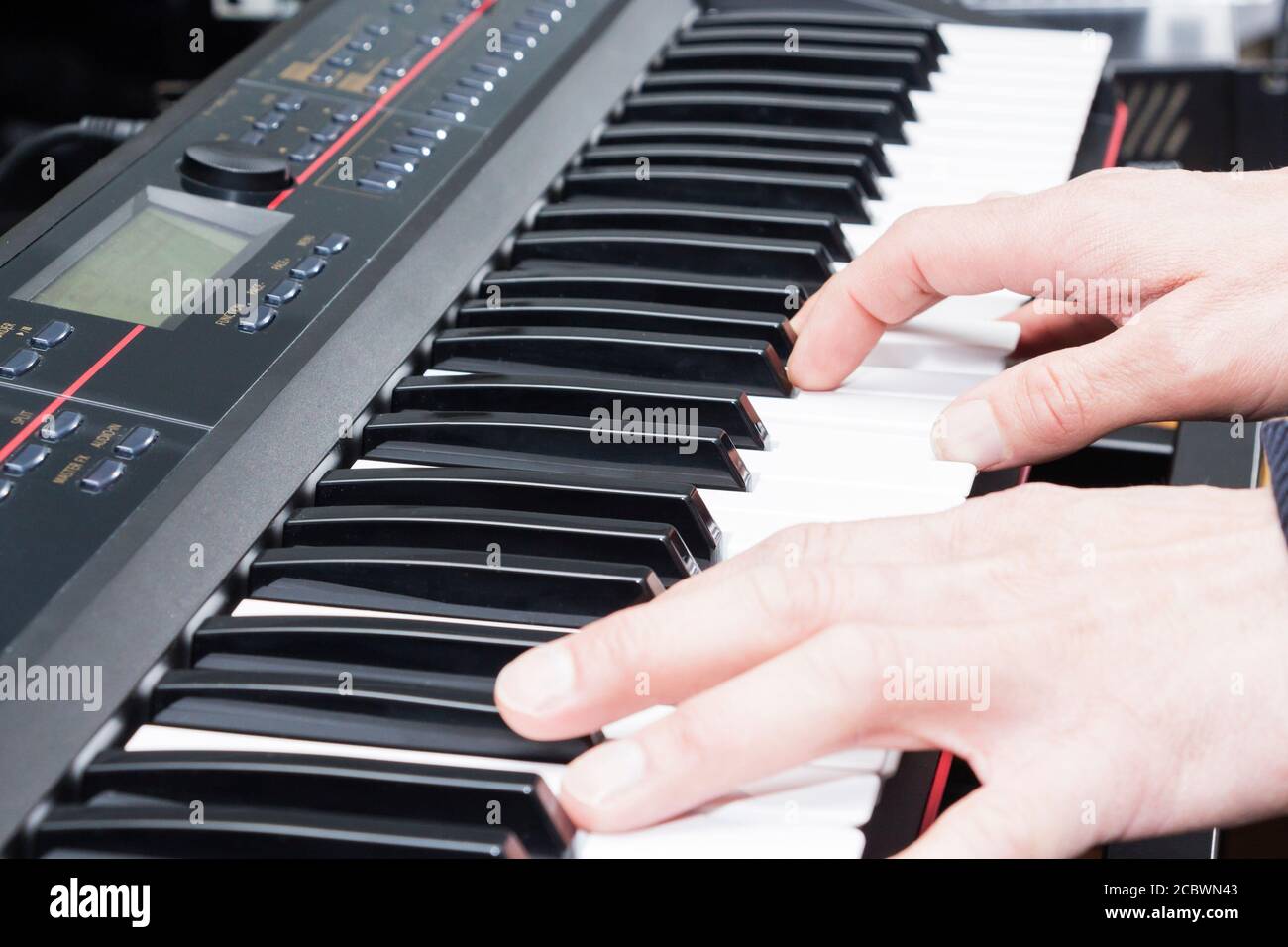 Primo piano della mano di un musicista che suona il pianoforte, la mano dell'uomo, la musica classica, la tastiera, il sintetizzatore, il pianista. Foto Stock
