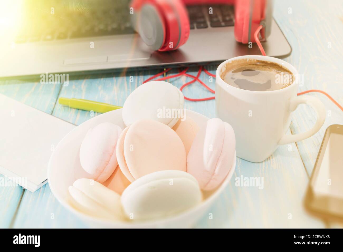 Il marshmallow è accanto al telefono e le cuffie rosse e una tazza di caffè nero. Pausa caffè. Musica piacevole. Foto Stock