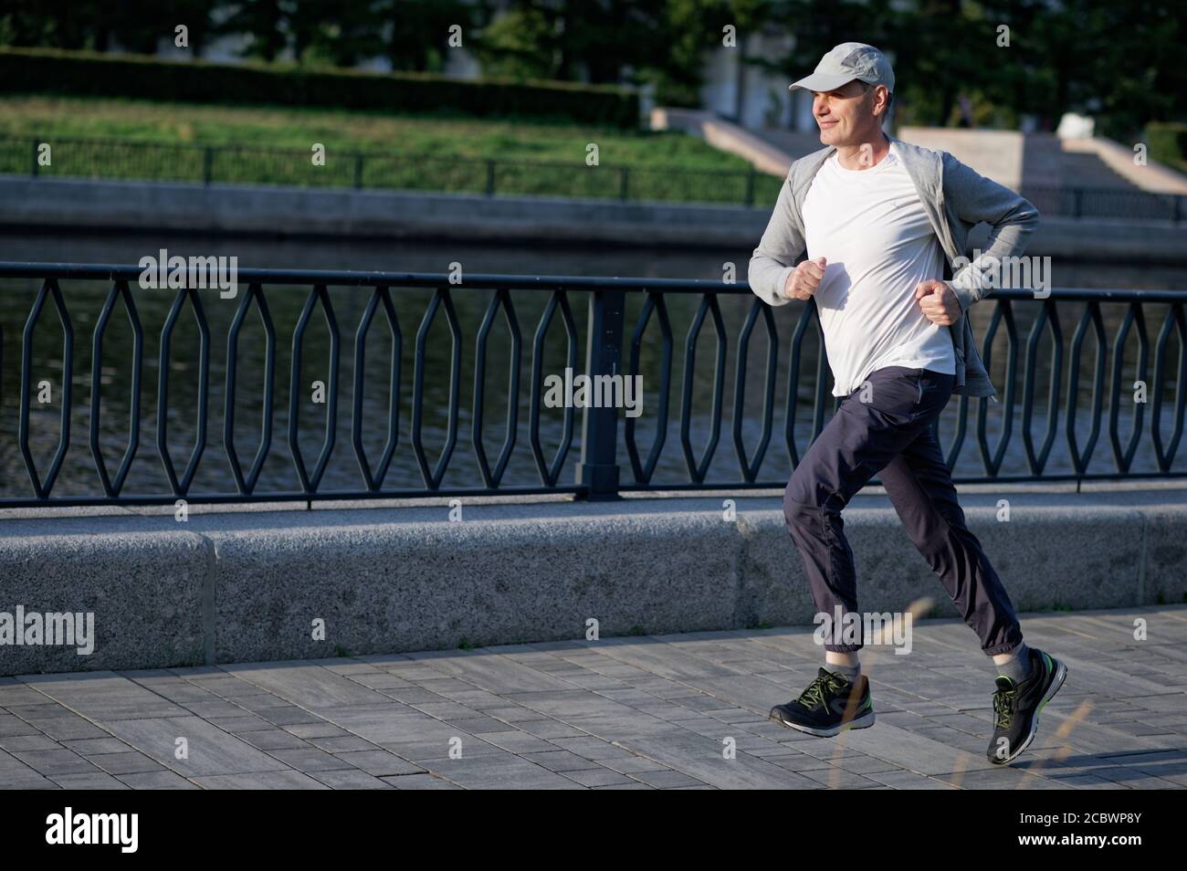 Uomo caucasico maturo che fa jogging in città Foto Stock