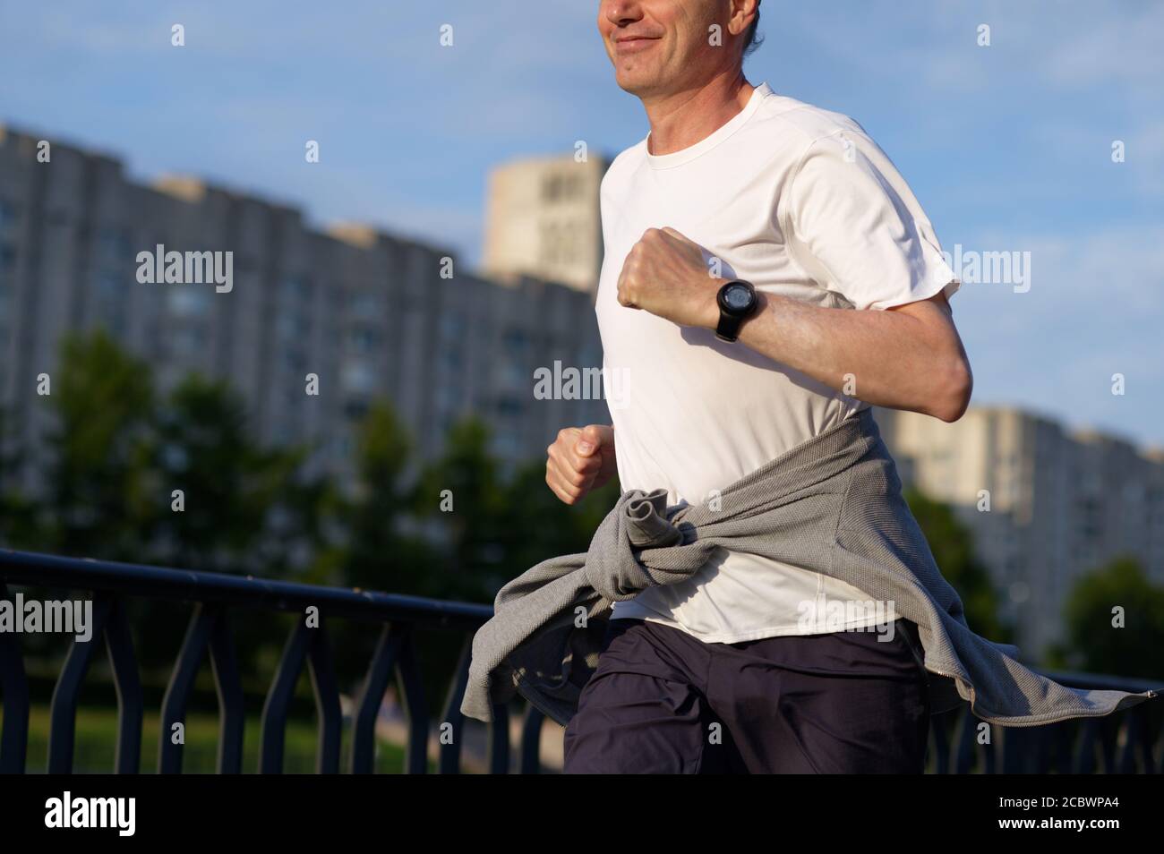 Uomo caucasico maturo che fa jogging in città Foto Stock