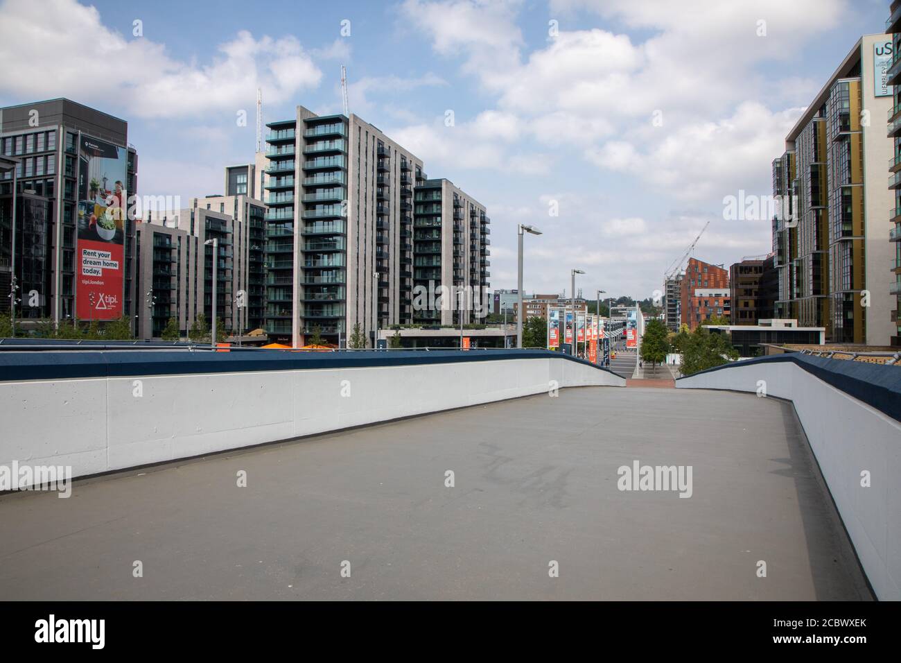 Wembley, con lo stadio dietro e fuori dalla vista. Questa immagine mostra una rampa pedonale con una nuova struttura ad alto rialzo. La Via Olimpica è in lontananza. Foto Stock