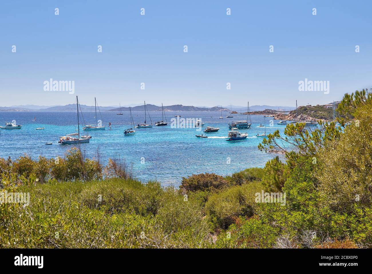 Isola Santa Maria, vista dalla cima della collina per le acque azzurre immacolate di mare sulla Sardegna, con yacht galleggianti Foto Stock