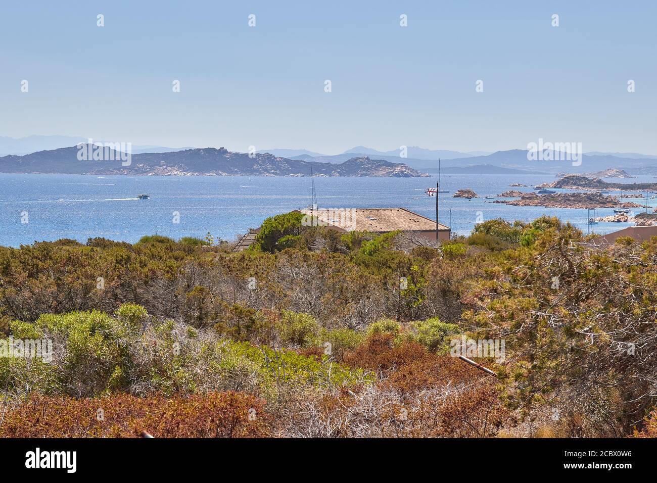 Isola Santa Maria, vista dalla cima della collina per le acque azzurre immacolate di mare sulla Sardegna, con yacht galleggianti Foto Stock
