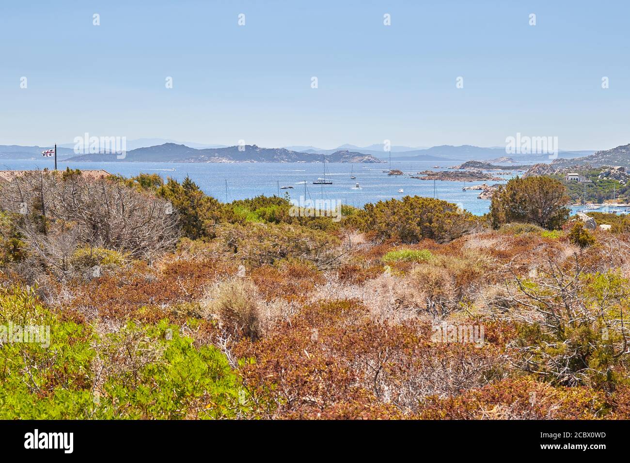 Isola Santa Maria, vista dalla cima della collina per le acque azzurre immacolate di mare sulla Sardegna, con yacht galleggianti Foto Stock