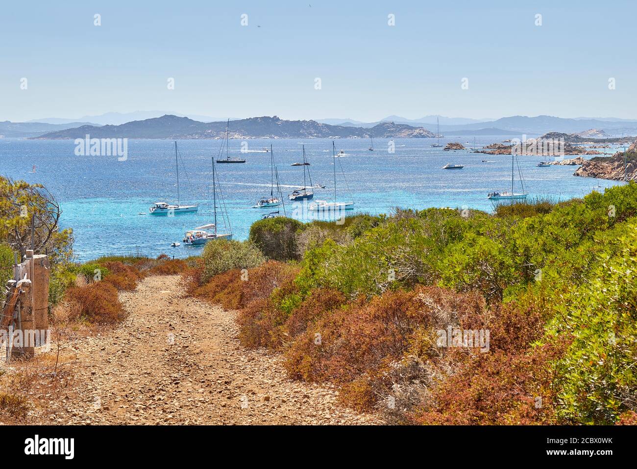 Isola Santa Maria, vista dalla cima della collina per le acque azzurre immacolate di mare sulla Sardegna, con yacht galleggianti Foto Stock