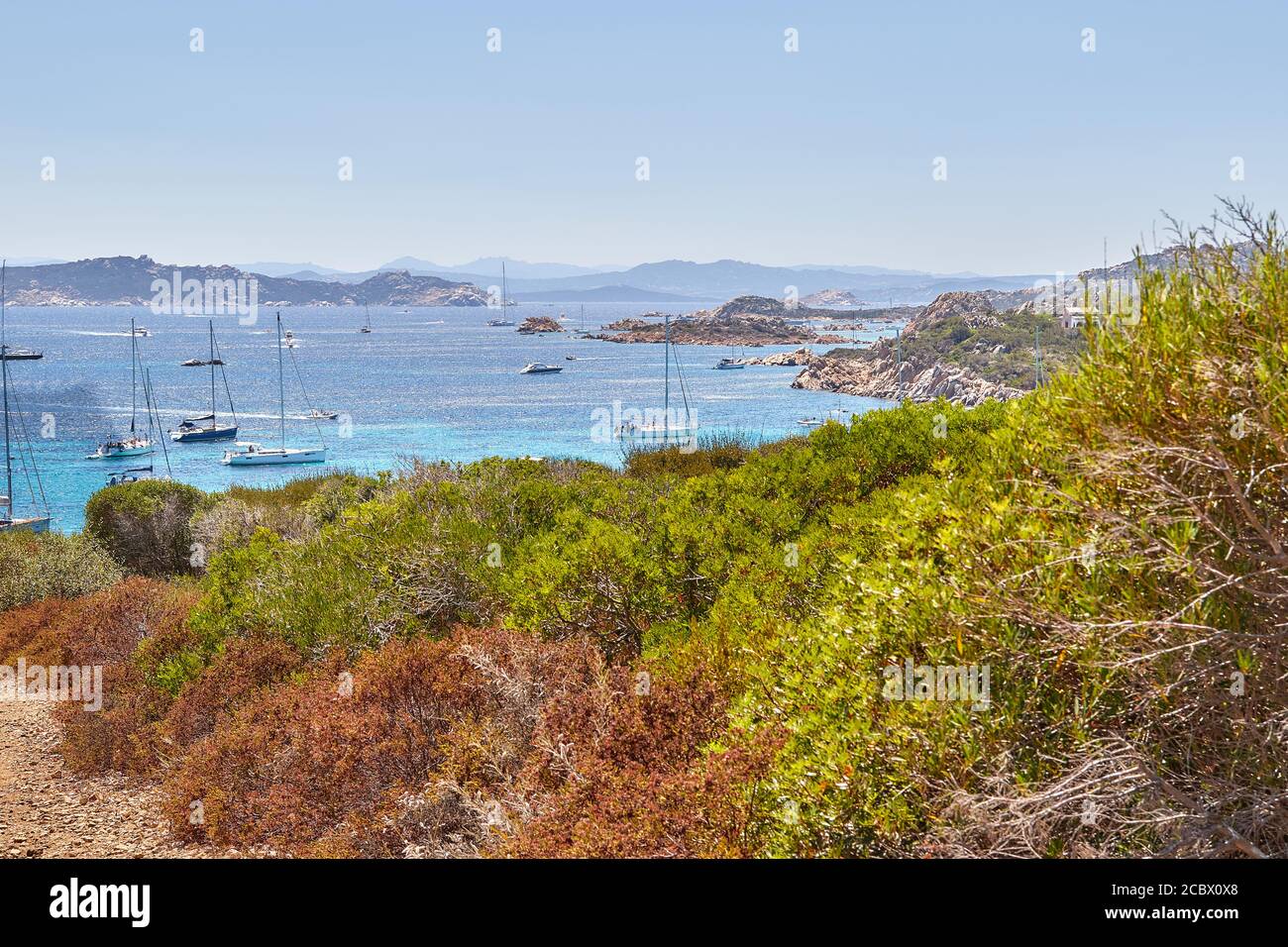 Isola Santa Maria, vista dalla cima della collina per le acque azzurre immacolate di mare sulla Sardegna, con yacht galleggianti Foto Stock