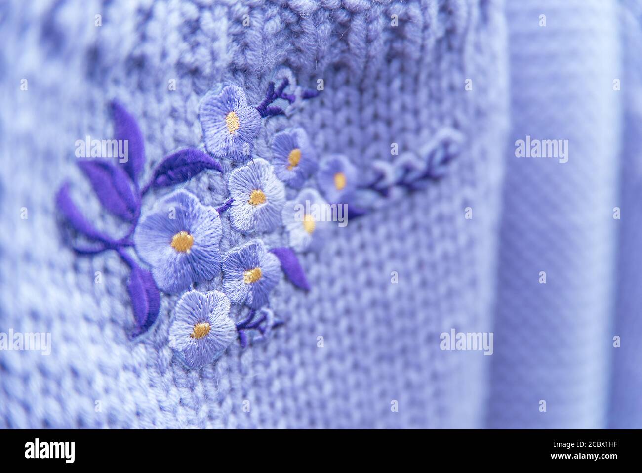 Fiore di ricamo fatto a mano su lana lilla Foto Stock