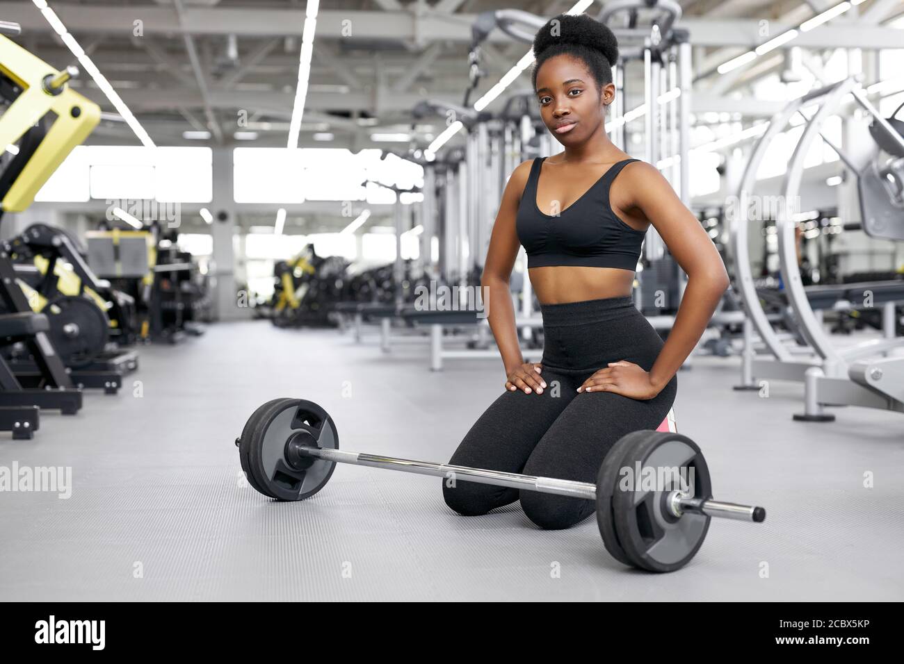 crossfit donna africana seduta in palestra, riposandosi, facendo una pausa  dopo l'allenamento cross-fit con barbell. potenza, forza, stile di vita  sano, concetto sportivo Foto stock - Alamy