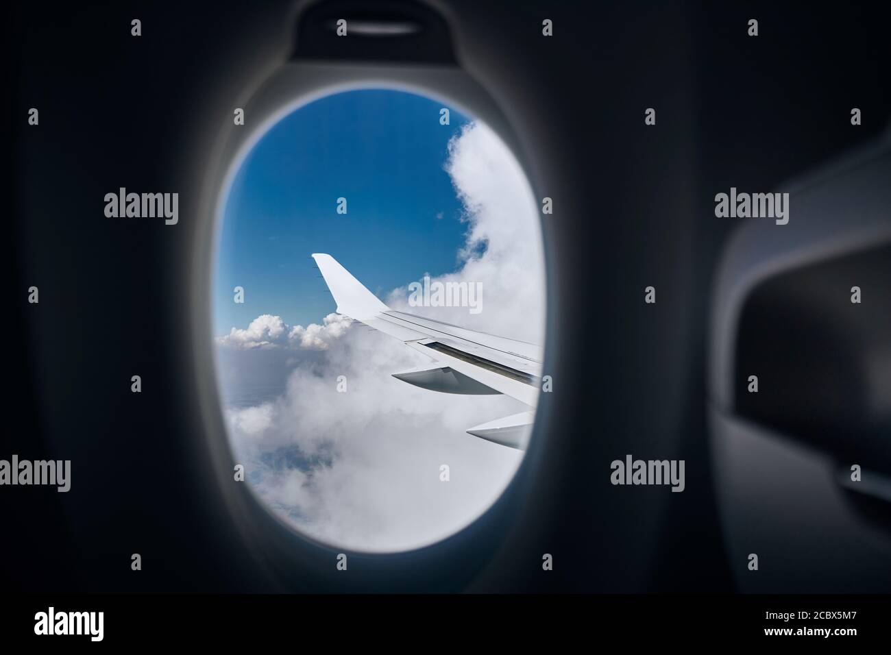 Vista dalla finestra dell'aereo. Alare durante il volo sopra le nuvole in giornata di sole. Foto Stock