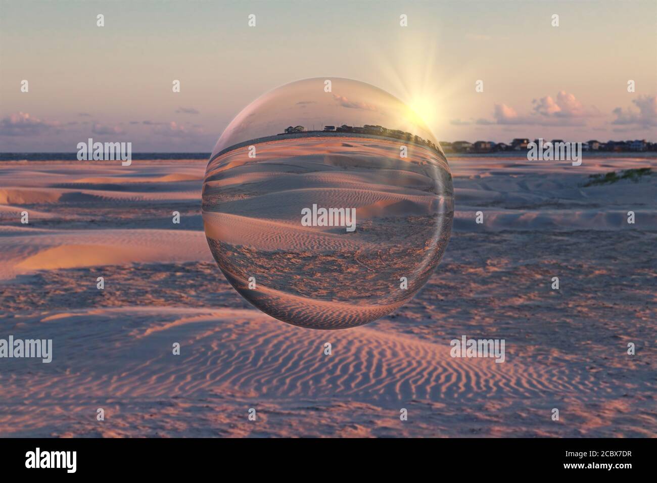 Tramonto sulla spiaggia di sabbia sull'isola di Galveston, Texas, Stati Uniti. Effetto artistico sfera di cristallo. Foto Stock