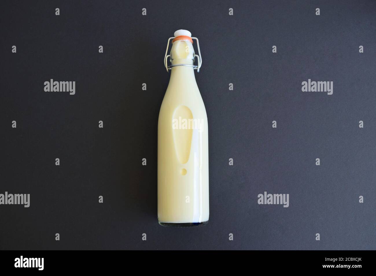 Biberon del latte isolato su sfondo scuro con spazio per la copia testo Foto Stock