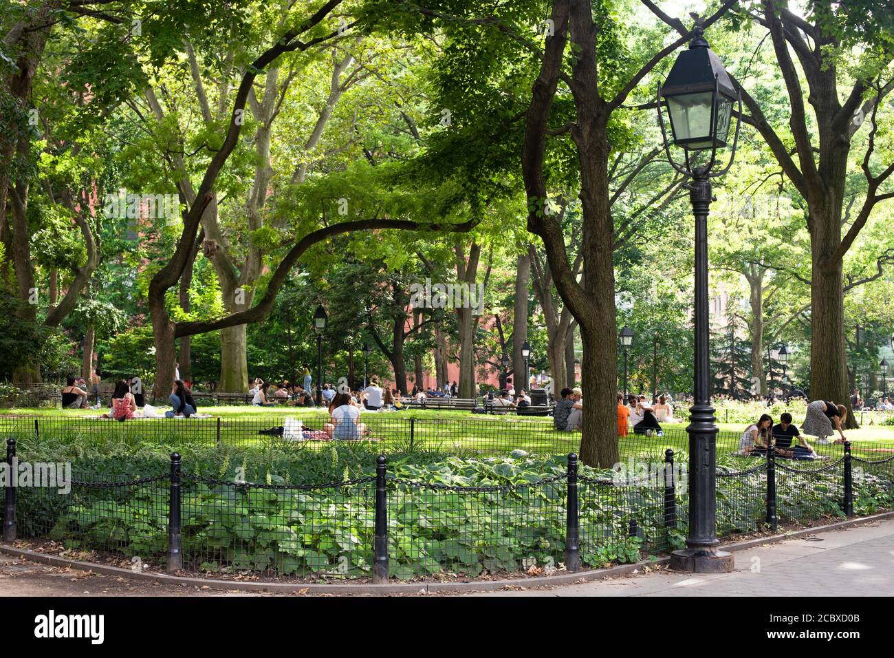 New York City - 15 agosto 2020: Le persone si rilassano in una scena estiva pomeridiana al Washington Square Park a Manhattan. Foto Stock