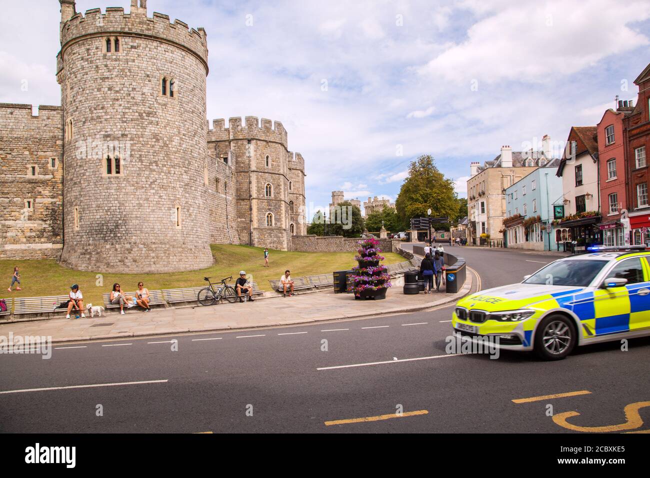 Macchina della polizia che passa davanti al Castello di Windsor nel Berkshire Inghilterra Regno Unito Foto Stock