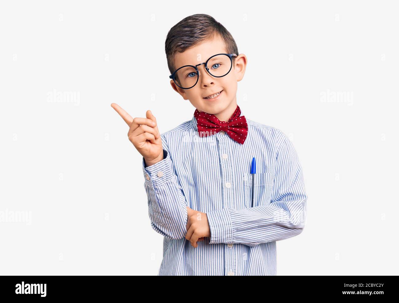 Carino bambino biondo che indossa cravatta di arco nerd e occhiali  sorridenti felice di puntare con mano e dito a lato Foto stock - Alamy