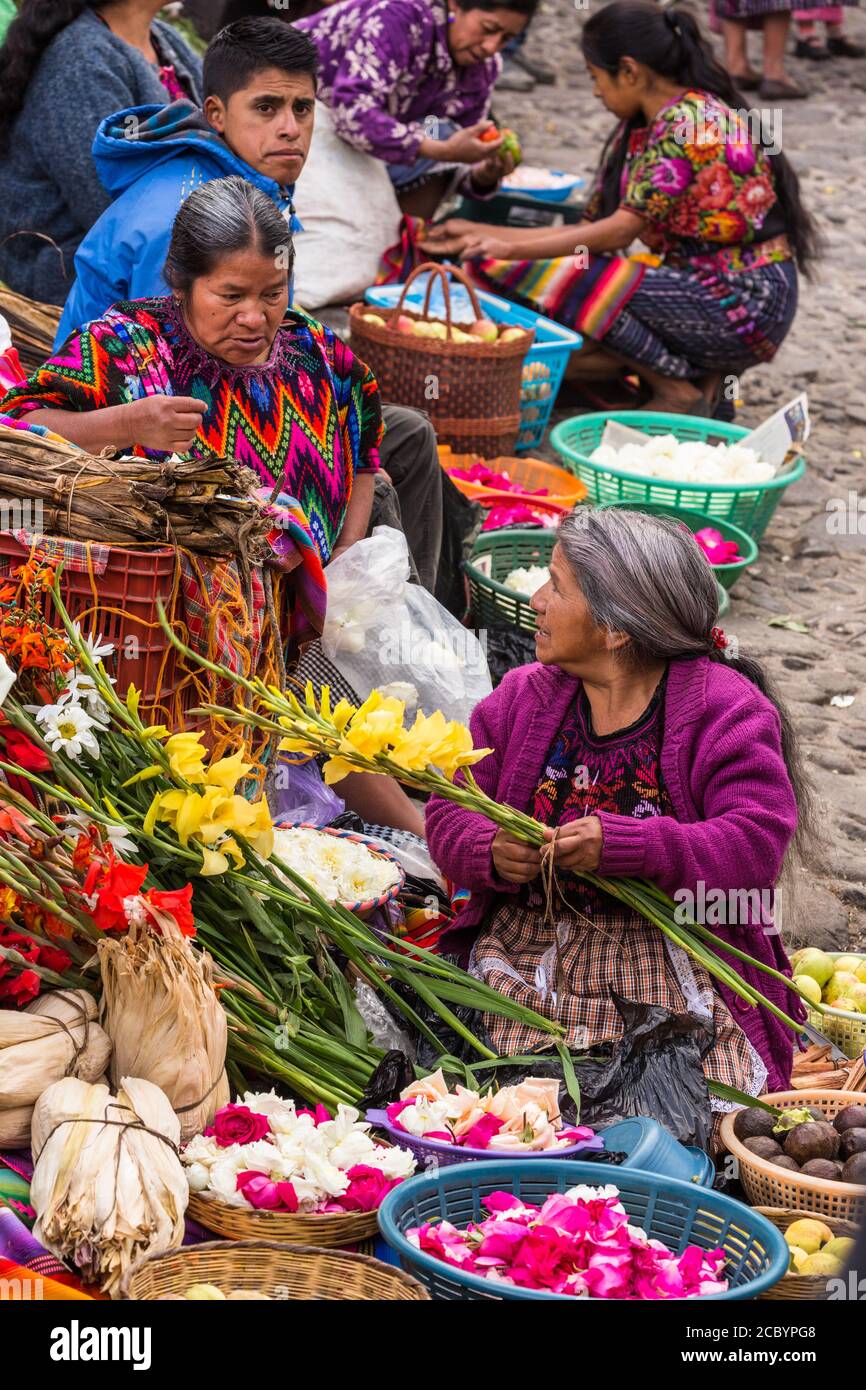 Le donne Maya Quiche vendono fiori nel mercato dei fiori sui gradini maya pre-ispanici di fronte alla Chiesa di Santo Tomas a Chichicastenango, Guatem Foto Stock