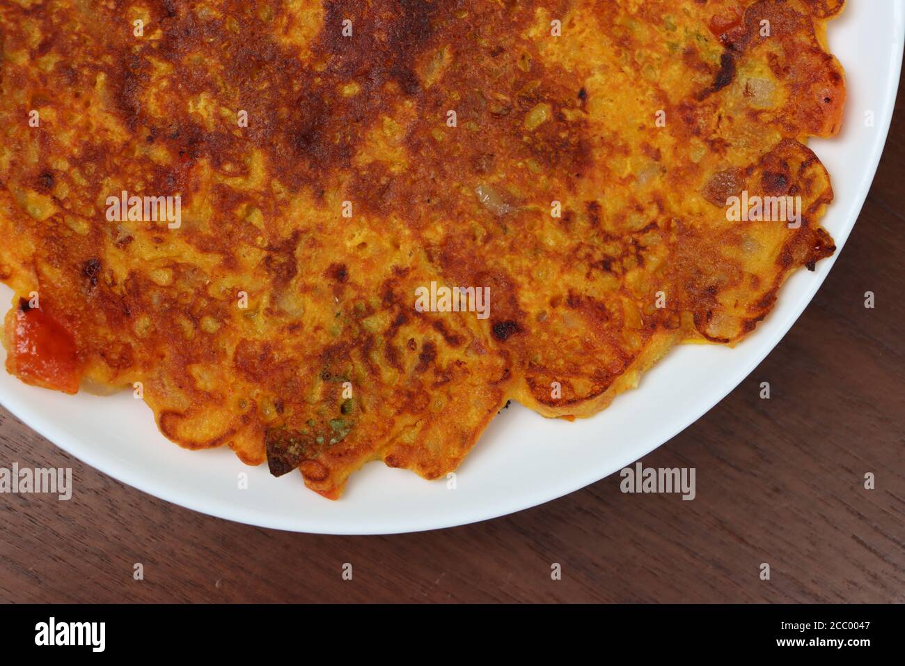 Omelette di pomodoro, è una frittella per la colazione preparata principalmente in Maharashtra.The ingrediente principale sono grammo di farina e pomodori, peperoncino verde, foglie di coriandolo Foto Stock