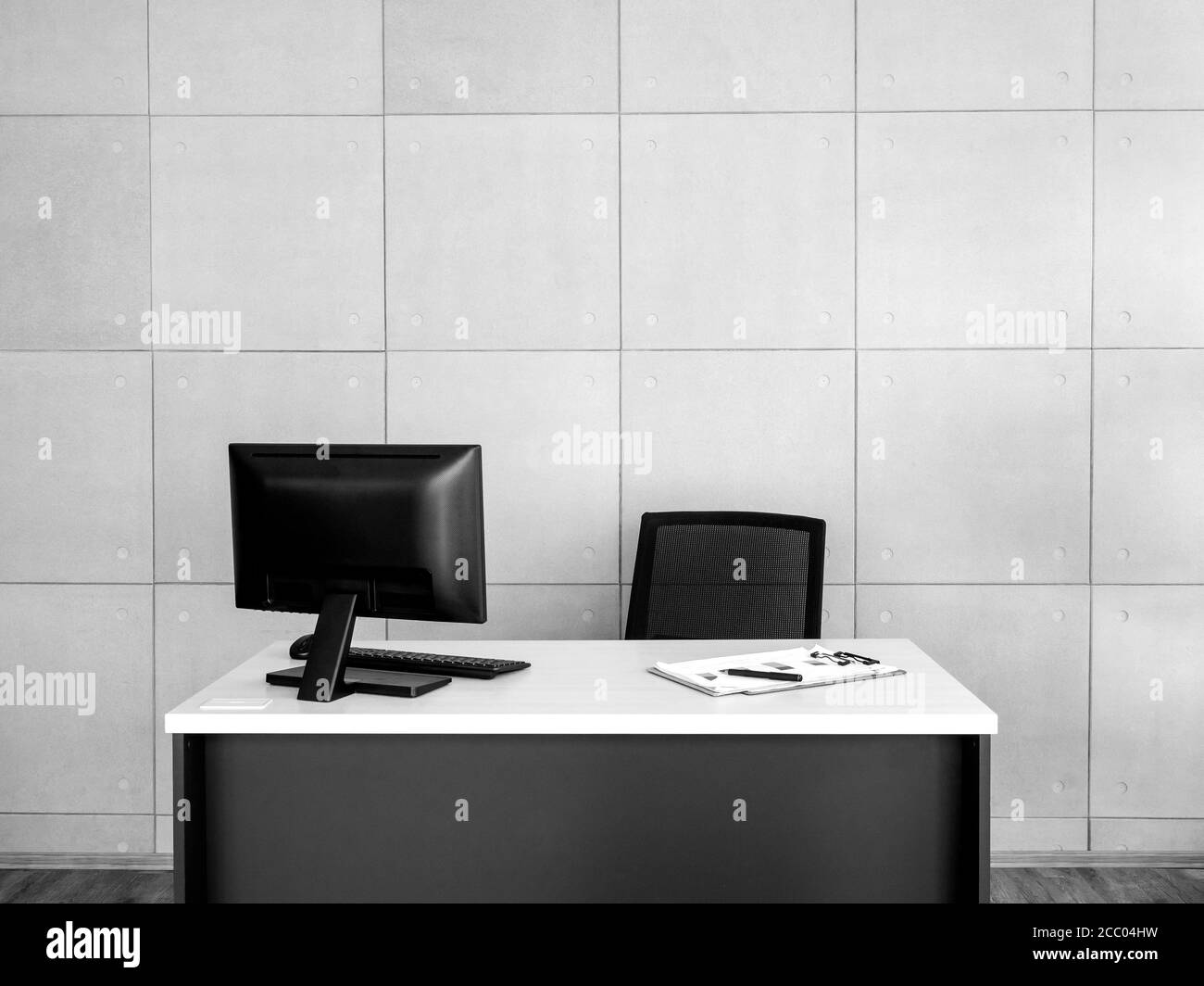 Interni moderni per uffici. Ambiente di lavoro ben illuminato con computer desktop e file di documenti sulla scrivania e sedia vuota su sfondo grigio a griglia con c Foto Stock