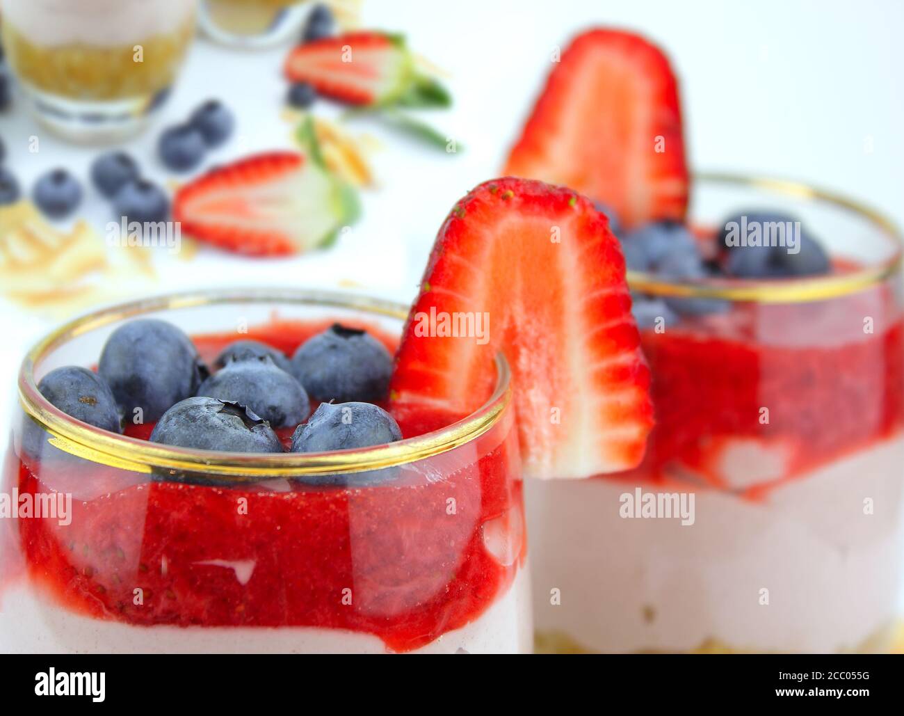 Torta di formaggio fatta in casa con una selezione di frutta e condimento di fragole. Foto Stock