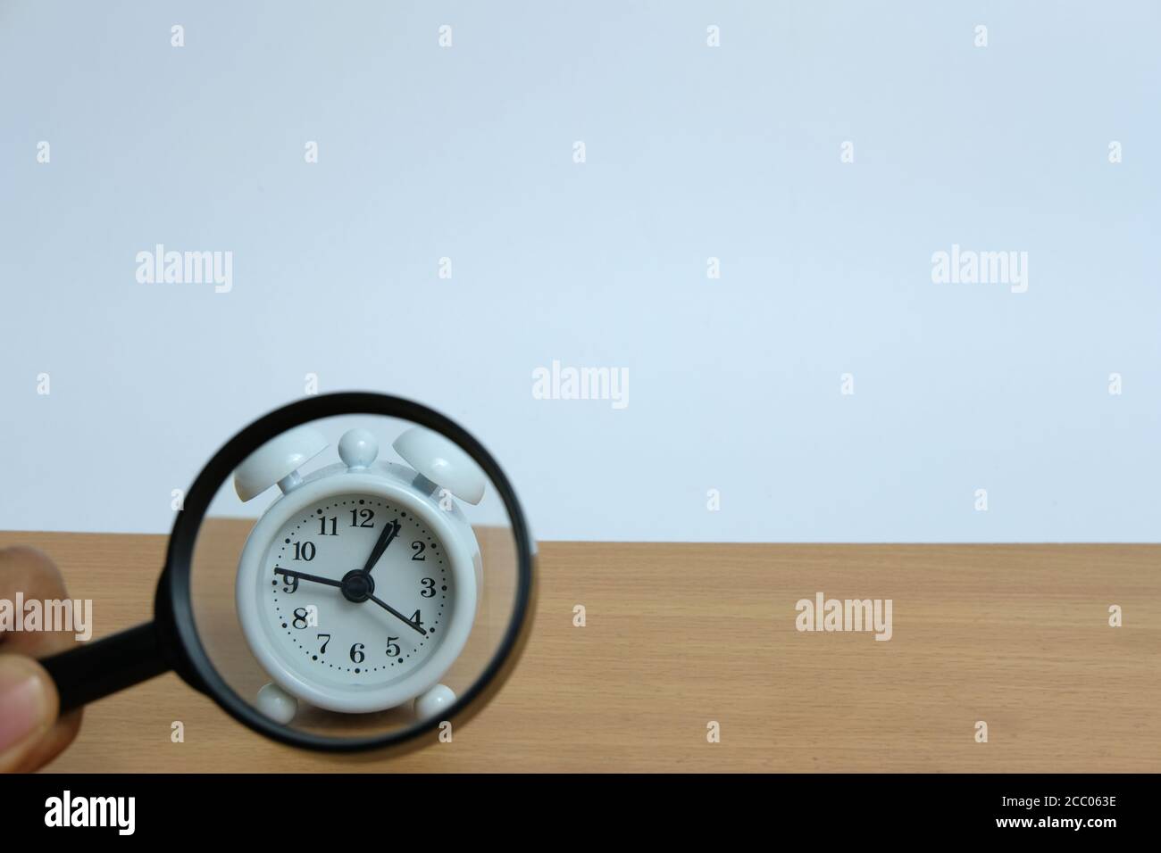 Guardare un orologio attraverso la lente d'ingrandimento Foto Stock
