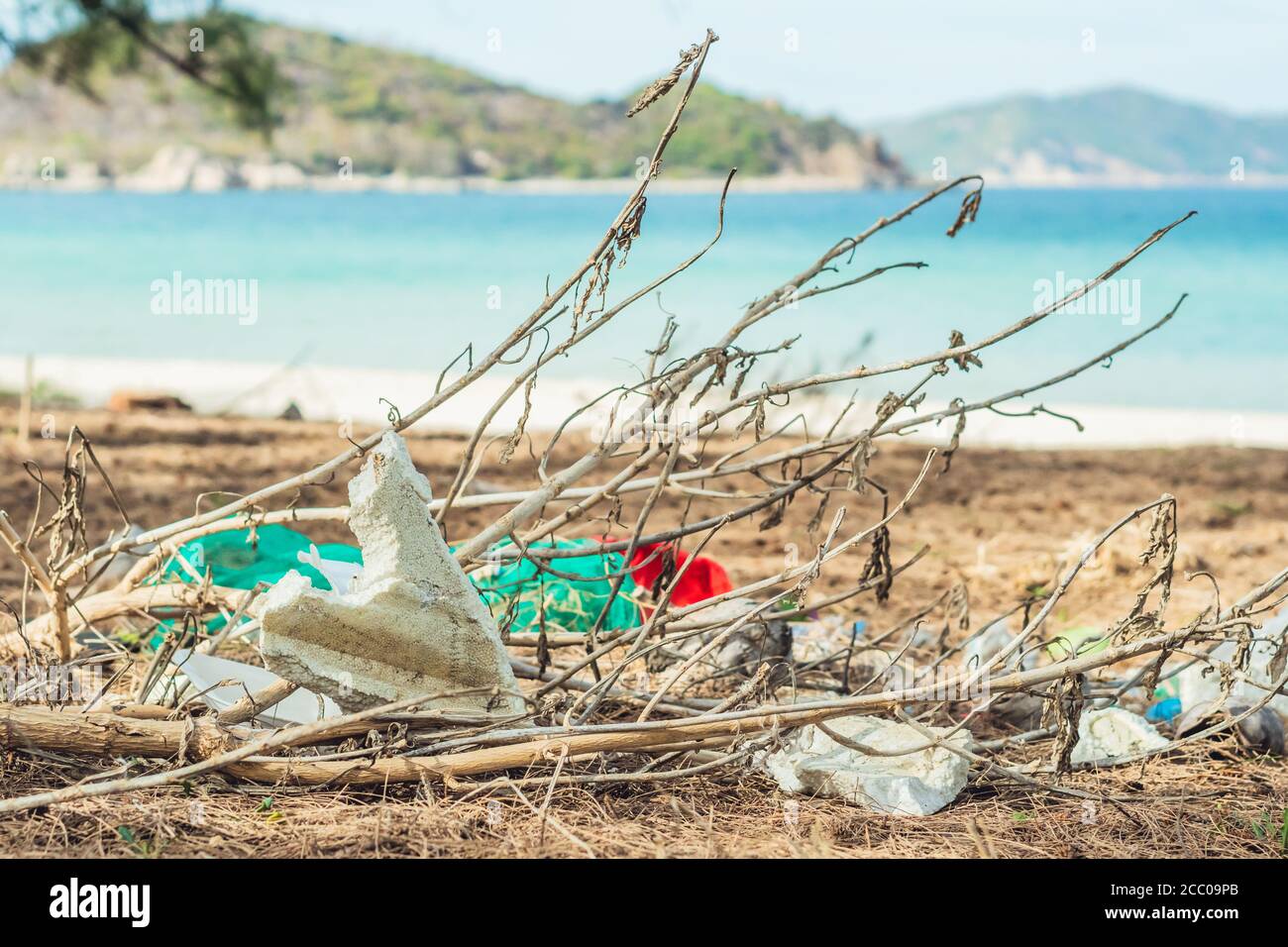 Rifiuti riciclati versato sulla spiaggia di lazur mare. Sacchetti di plastica e schiuma bianca usati. Inquinamento ambientale totale, problema ecologico, globale Foto Stock