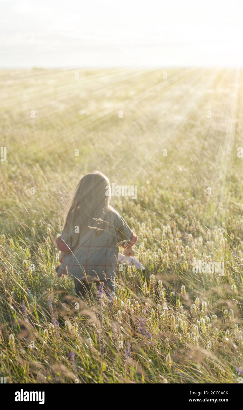 Bambina che corre nel campo autunnale all'alba. Concetto autunnale Foto Stock