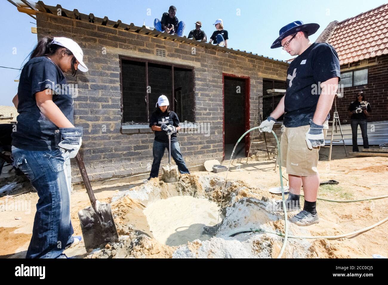 Soweto, Sudafrica - 05 settembre 2009: Programma comunitario di azione che mescola cemento per costruire una piccola casa a prezzi accessibili Foto Stock