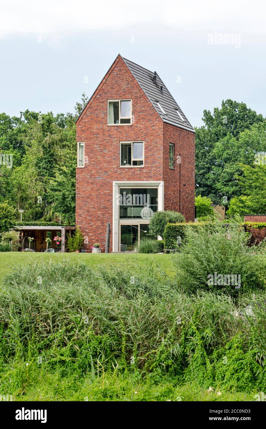 Zwolle, Paesi Bassi, 27 luglio 2020: Lussuosa casa a quattro piani con una forma tradizionale ed elementi moderni in un ambiente verde Foto Stock