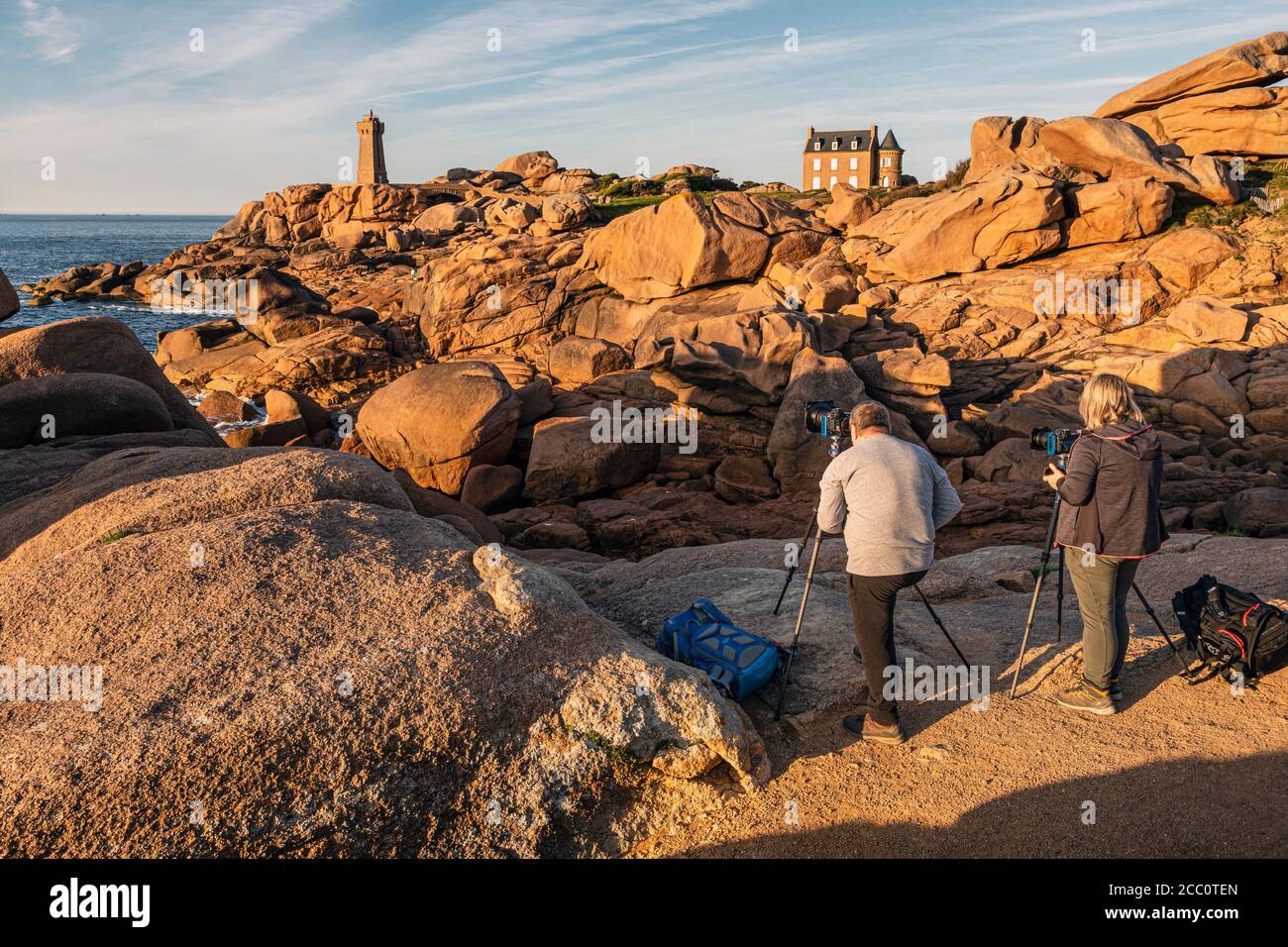 Fotografi che fotografano il tramonto al faro di Ploumanac'h, Pink Granite Coast, Bretagna, Francia Foto Stock
