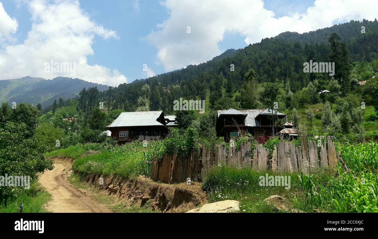 Una vista villaggio case legno recinzioni colture collina cielo verde una strada nel quartiere di kupwara jammu e kashmir 2012 Foto Stock