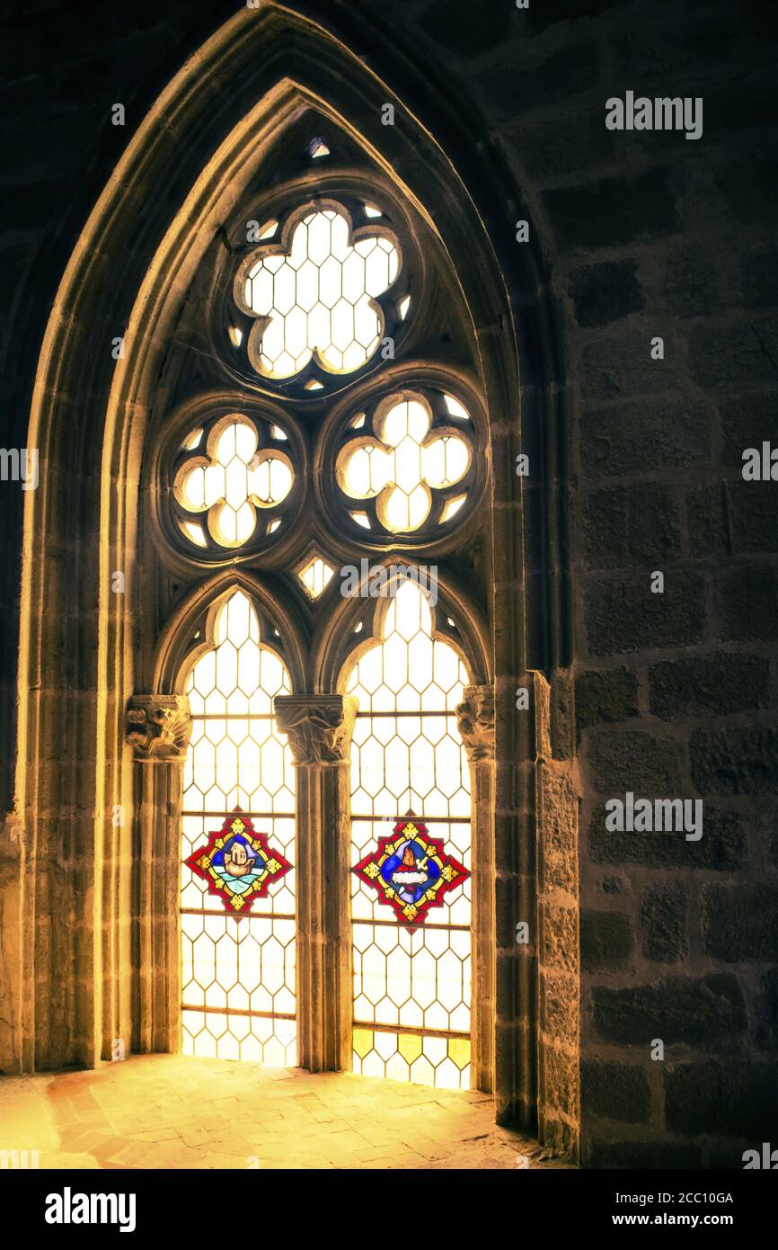Luce solare che splende attraverso vetrate di una finestra gotica di una chiesa. Foto Stock