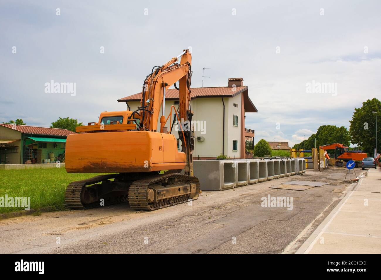 Escavatore cingolato con piattaforma girevole e cingolo continuo caterpillar con cassoni in cemento armato. Sito di sostituzione delle acque reflue, Italia Foto Stock