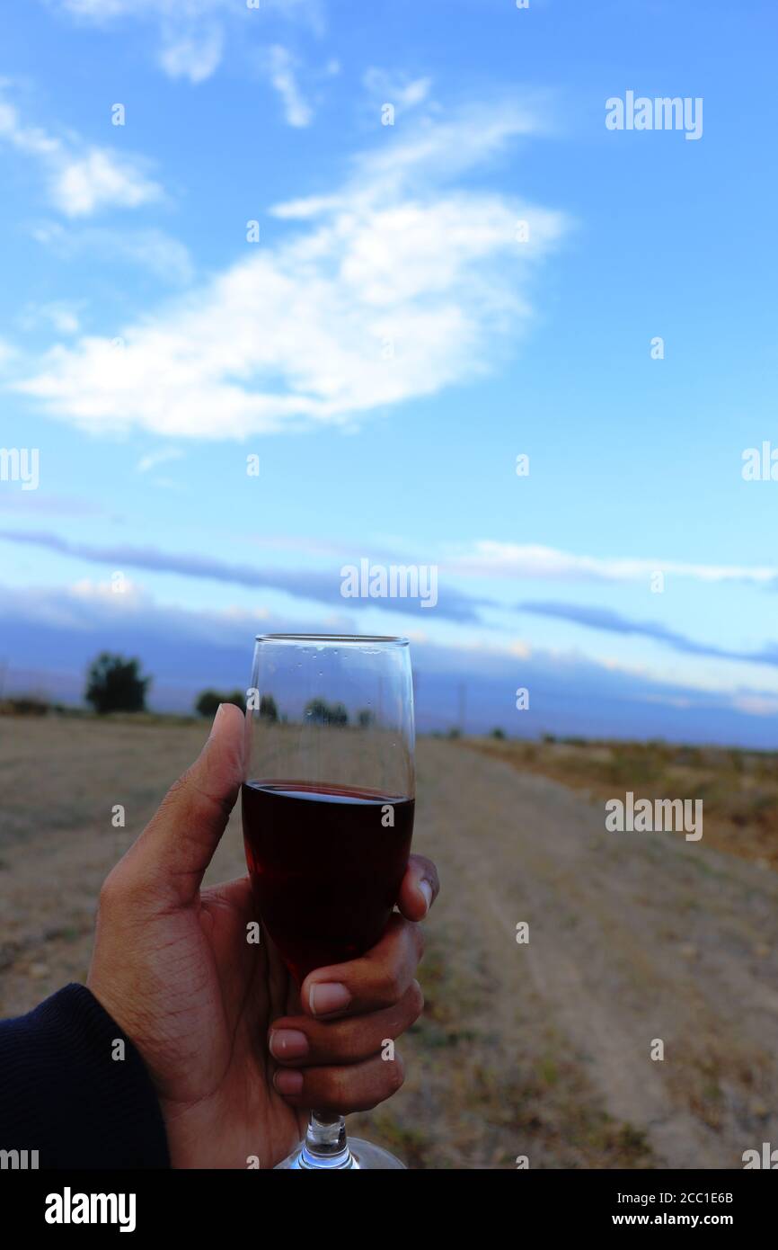 Un bicchiere di tè turco in mano con il blu cielo come sfondo Foto Stock