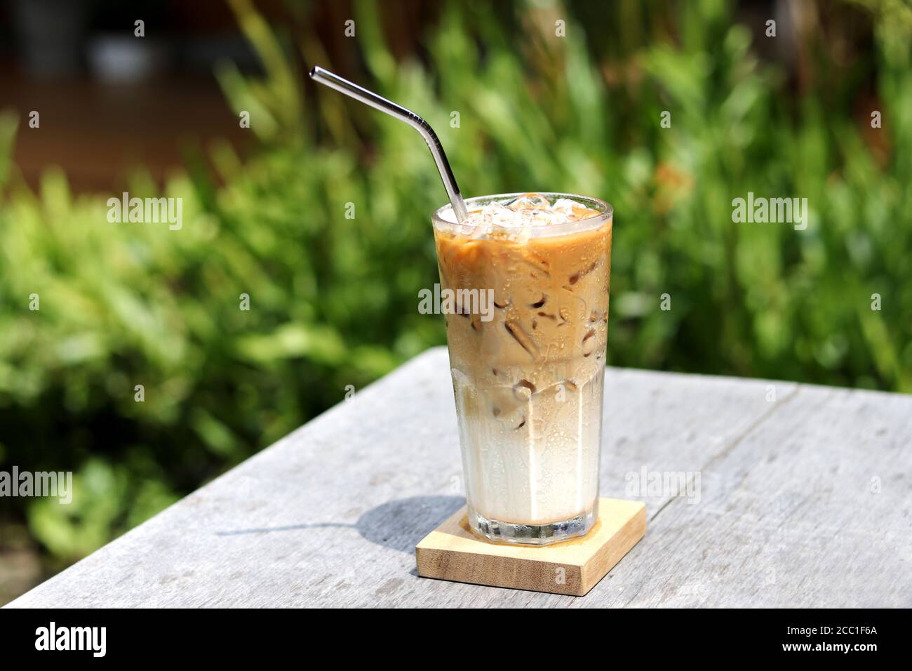 Caffè macchiato al caramello ghiacciato con cannuccia in acciaio inox per bevande. Concetto per ridurre l'inquinamento plastico e sostenere prodotti ecologici. Foto Stock